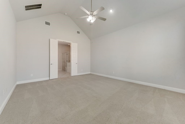 unfurnished bedroom with ceiling fan, connected bathroom, light carpet, and high vaulted ceiling