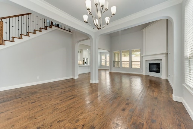 unfurnished living room with ornamental molding, dark hardwood / wood-style floors, and a chandelier