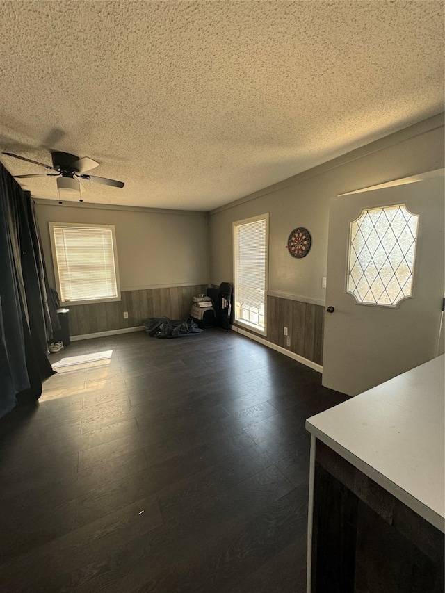 unfurnished living room with ceiling fan, wood-type flooring, and a textured ceiling