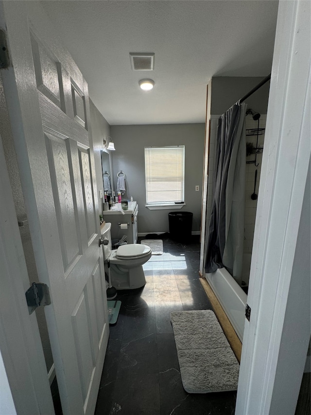 bathroom featuring tile patterned floors, shower / bathtub combination with curtain, and toilet