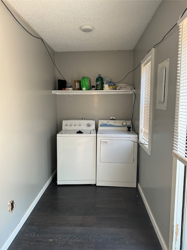 clothes washing area with washing machine and clothes dryer, a textured ceiling, and dark hardwood / wood-style floors