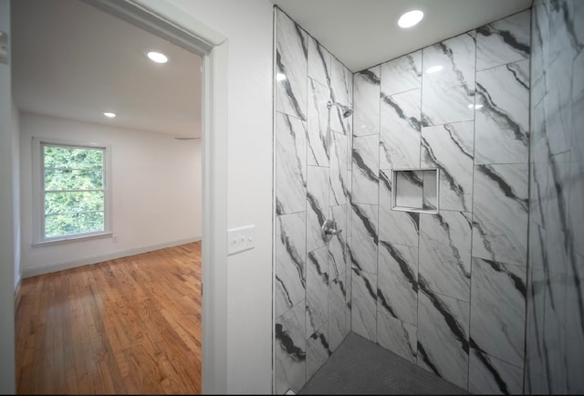 bathroom featuring a tile shower and hardwood / wood-style floors