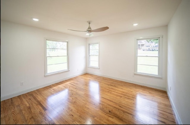 empty room with ceiling fan and light hardwood / wood-style flooring