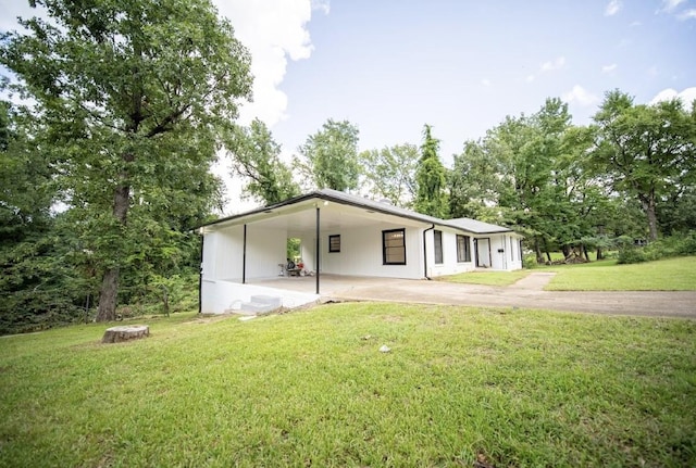 view of front of home with a carport and a front lawn