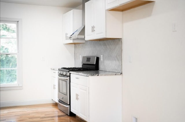 kitchen with white cabinetry, a healthy amount of sunlight, stainless steel gas range, and tasteful backsplash