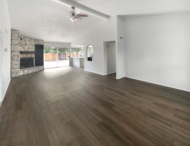 unfurnished living room with a fireplace, ceiling fan, lofted ceiling with beams, dark hardwood / wood-style floors, and a textured ceiling