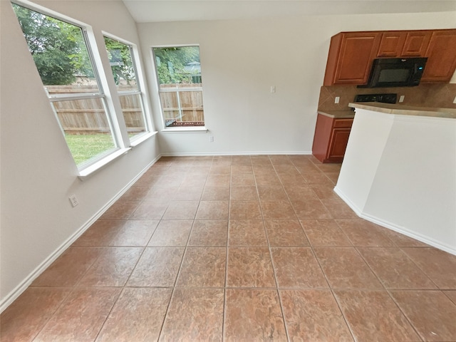 interior space featuring light tile patterned flooring, vaulted ceiling, and a wealth of natural light