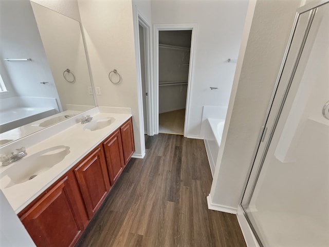 bathroom featuring separate shower and tub, wood-type flooring, and dual bowl vanity