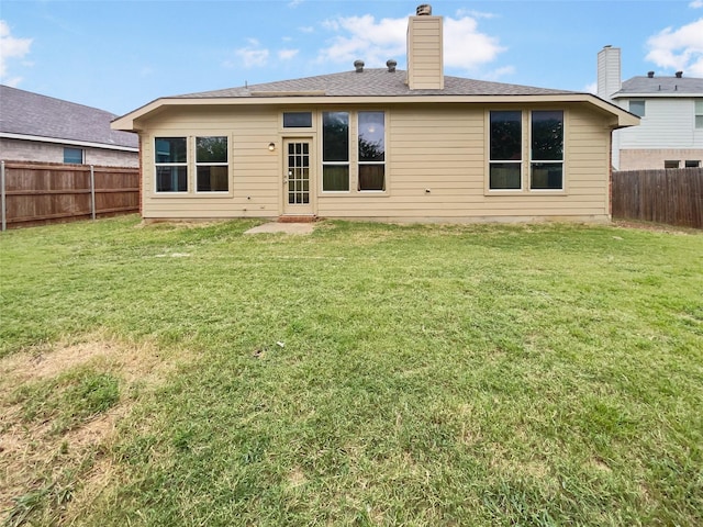 back of house featuring a lawn