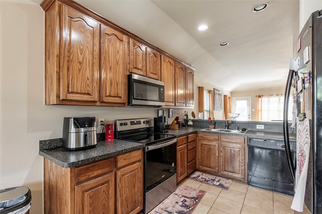 kitchen with black appliances, light tile patterned floors, kitchen peninsula, and sink