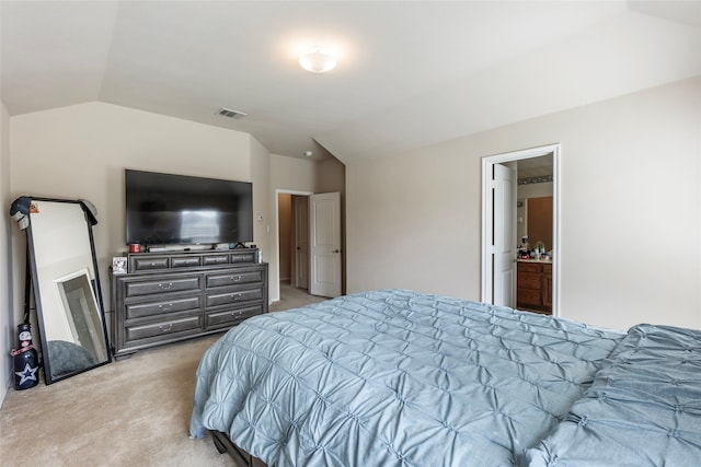 carpeted bedroom with vaulted ceiling and ensuite bath