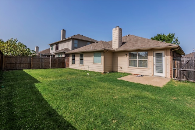 rear view of house with a yard and a patio