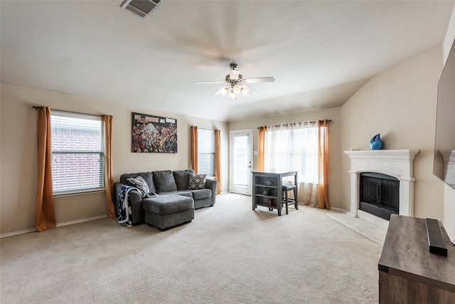 living room featuring ceiling fan, light colored carpet, and a healthy amount of sunlight