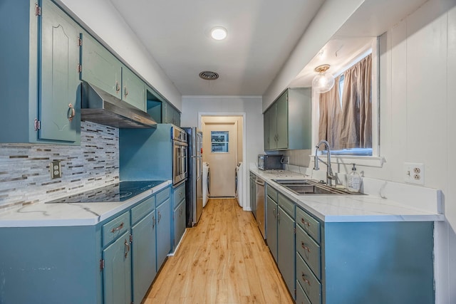 kitchen featuring stainless steel appliances, backsplash, sink, and light wood-type flooring