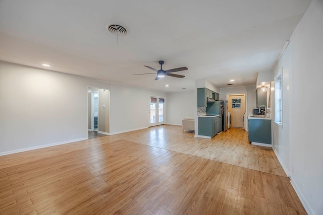 unfurnished living room with light wood-type flooring and ceiling fan