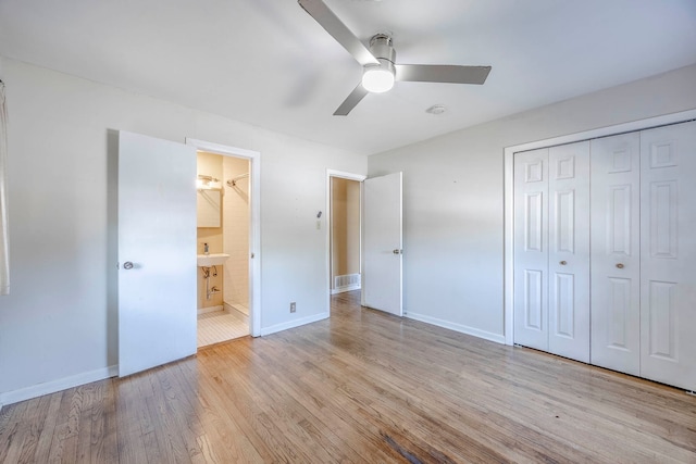 unfurnished bedroom featuring a closet, light hardwood / wood-style floors, connected bathroom, and ceiling fan