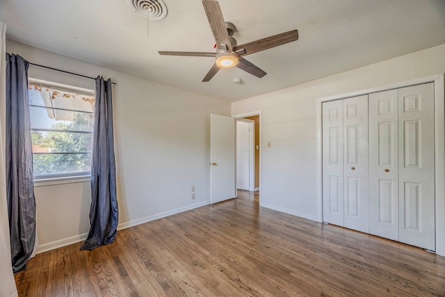 unfurnished bedroom featuring hardwood / wood-style flooring, ceiling fan, and a closet