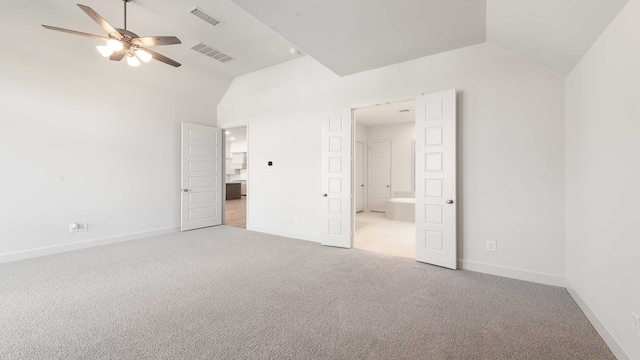 unfurnished bedroom featuring lofted ceiling, ceiling fan, ensuite bathroom, and light colored carpet