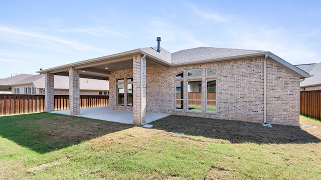 back of property featuring a patio and a lawn