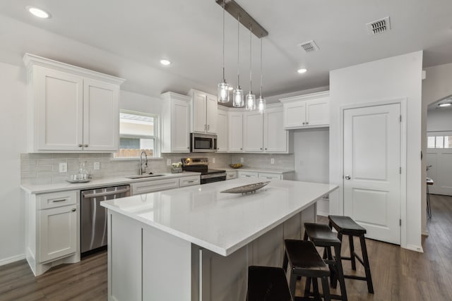 kitchen with plenty of natural light, a kitchen island, dark hardwood / wood-style floors, and stainless steel appliances