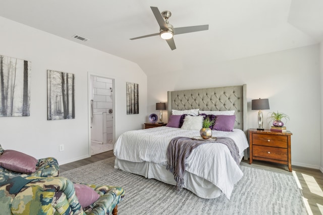 bedroom featuring ensuite bathroom, ceiling fan, light wood-type flooring, and lofted ceiling