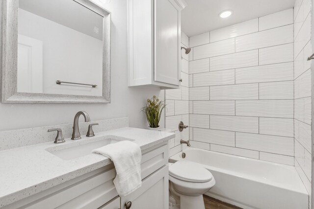 full bathroom featuring wood-type flooring, vanity, toilet, and tiled shower / bath