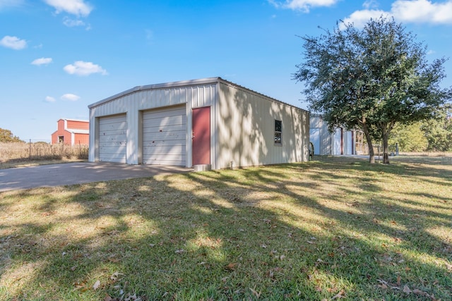 view of front facade with a garage, a front lawn, and an outbuilding