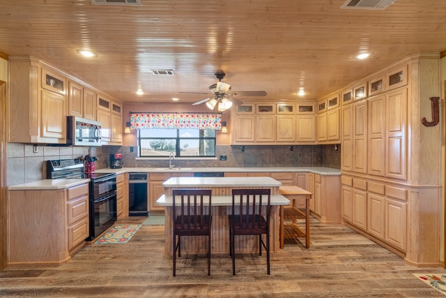 kitchen featuring a center island, light hardwood / wood-style floors, black appliances, and wood ceiling