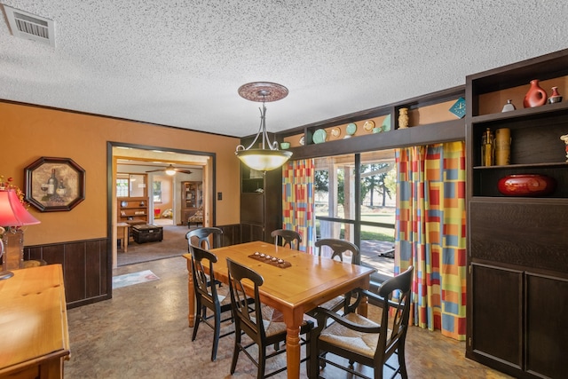 dining room featuring ceiling fan, crown molding, and a textured ceiling