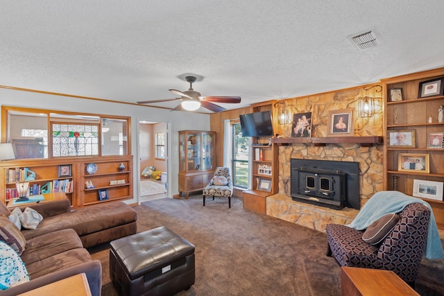 living room with ceiling fan, a fireplace, carpet floors, and a textured ceiling