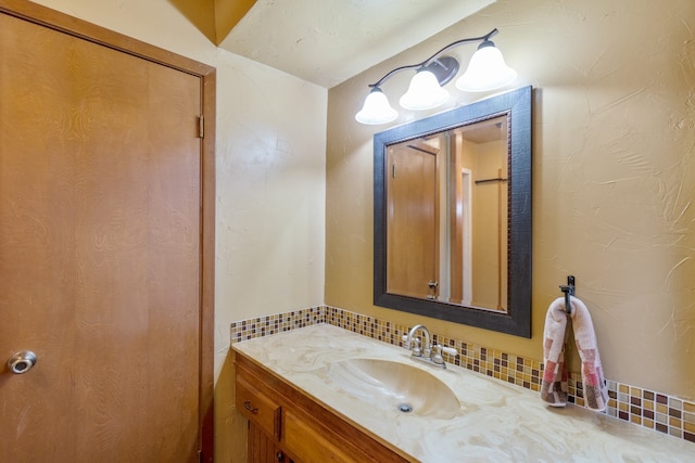 bathroom with vanity and tasteful backsplash