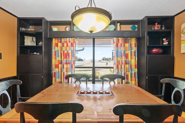 dining area featuring ornamental molding and a textured ceiling