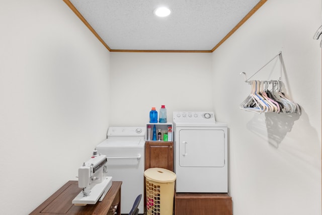 clothes washing area featuring ornamental molding, a textured ceiling, and washing machine and clothes dryer