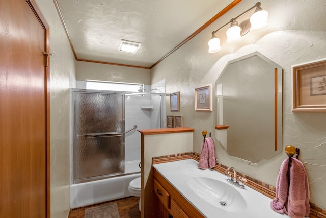 full bathroom featuring vanity, tile patterned floors, combined bath / shower with glass door, ornamental molding, and toilet