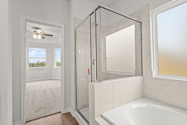 bathroom featuring hardwood / wood-style flooring, ceiling fan, and separate shower and tub