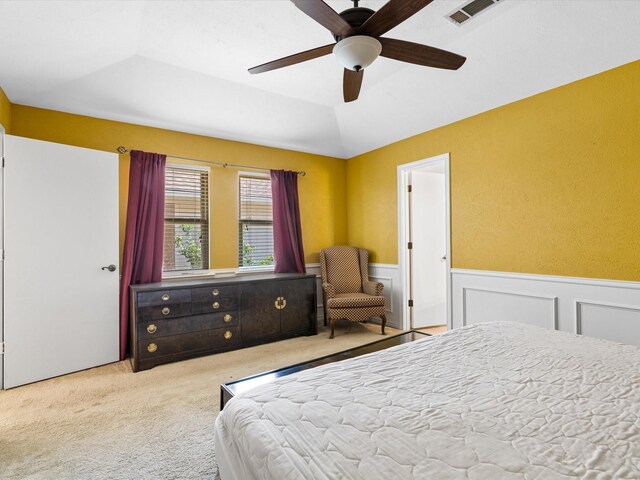 bedroom with light carpet, ceiling fan, vaulted ceiling, and a tray ceiling