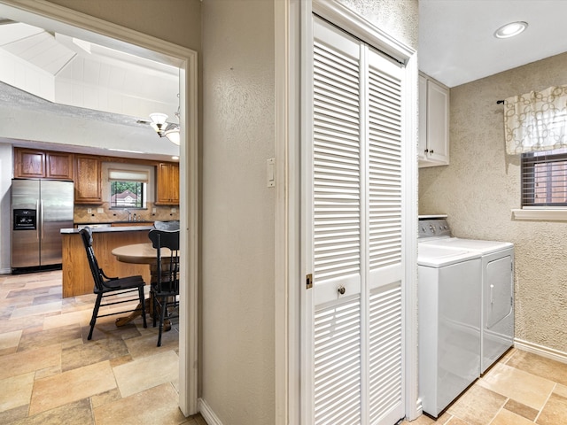 clothes washing area with light tile patterned floors, washer and dryer, sink, and cabinets