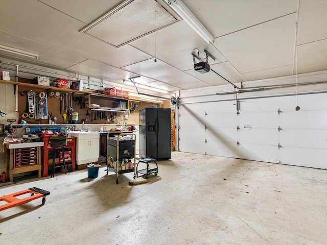 garage featuring black fridge, a workshop area, and a garage door opener