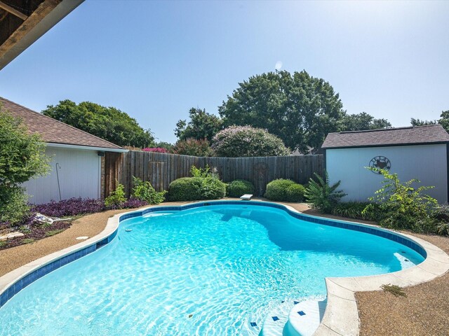 view of swimming pool featuring an outbuilding