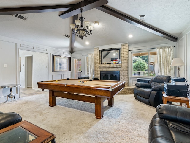 game room with a textured ceiling, pool table, light colored carpet, brick wall, and a fireplace