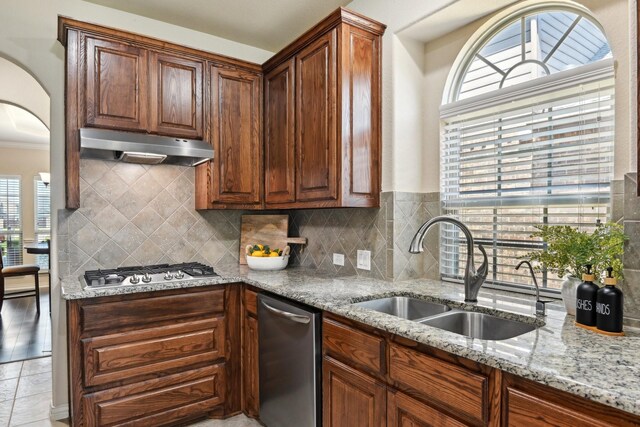 kitchen featuring sink, backsplash, light tile patterned flooring, and a wealth of natural light