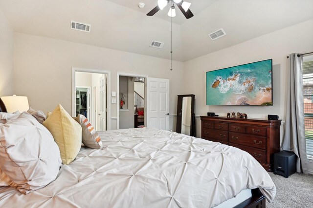 bedroom featuring ceiling fan, vaulted ceiling, and light colored carpet