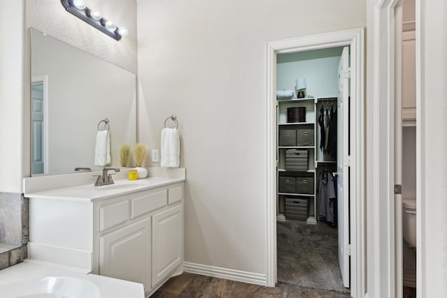 bathroom with vanity, wood-type flooring, and toilet