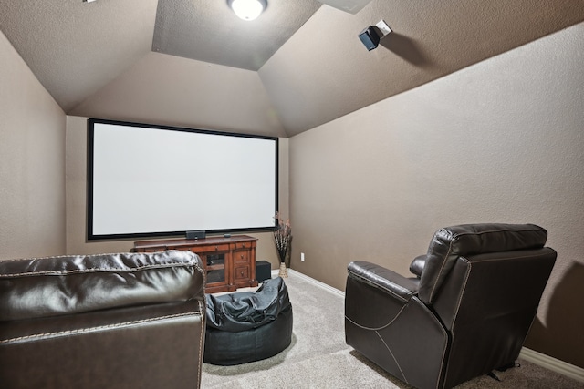 home theater featuring a textured ceiling, lofted ceiling, and light carpet