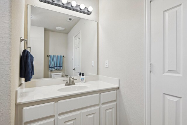 bathroom featuring vanity and toilet