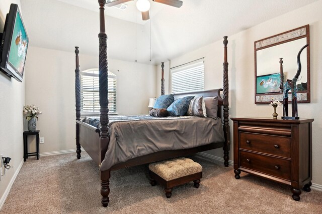 bedroom with ceiling fan, light carpet, and multiple windows