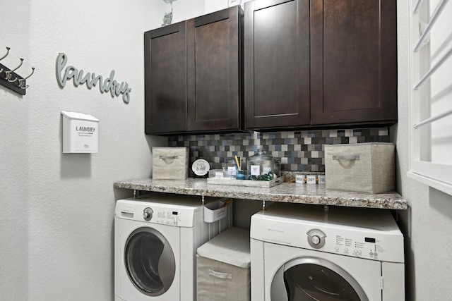 clothes washing area featuring washing machine and clothes dryer and cabinets