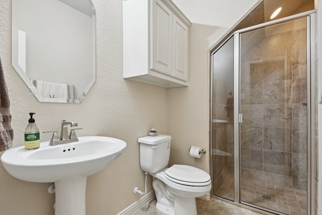 bathroom featuring toilet, tile patterned floors, and a shower with shower door