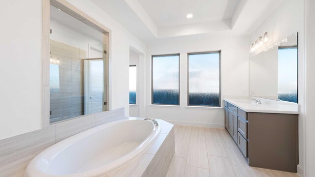 bathroom with vanity, a tray ceiling, and shower with separate bathtub