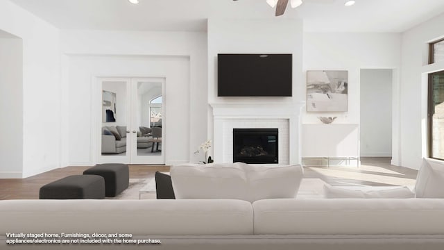 living room featuring hardwood / wood-style floors, a brick fireplace, and ceiling fan